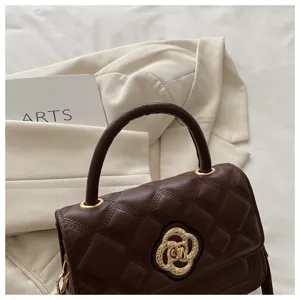 Elegante braune gesteppte Umhängetasche aus Leder mit schickem goldenem Blumenverschluss.
