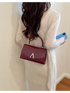 Borsa a tracolla chic in pelle verniciata da donna con ciondolo A e catena elegante.