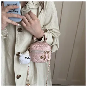 Primer plano de un mini bolso de hombro rosa acolchado con cadena y colgante suave y bonito.