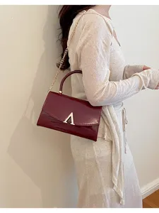 Borsa a tracolla da donna in pelle verniciata con catena dorata e chiusura con logo V.