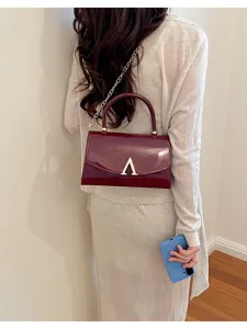 Borsa a tracolla da donna in pelle verniciata con catena e chiusura metallica, elegante e chic.