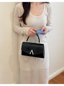 Borsa a tracolla elegante in pelle verniciata da donna con chiusura metallica.