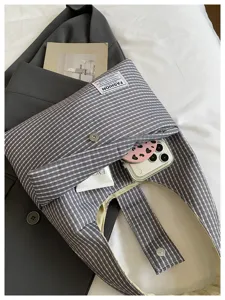 Detailed view of grey plaid hobo shoulder bag with casual design and soft fabric texture.