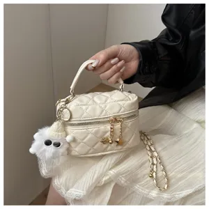Vista detallada del mini bolso acolchado blanco, elegante bolso cruzado con lindo colgante de felpa.