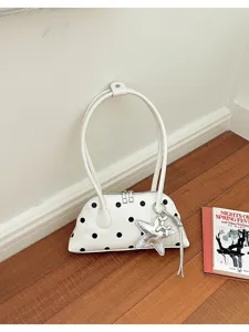 Gedetailleerd overzicht van een elegante witte gestippelde bowlingtas met sterrenhanger.