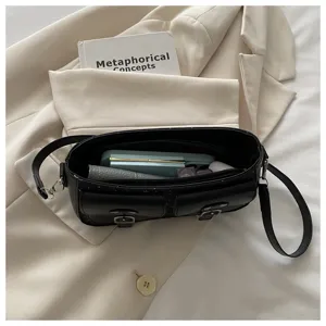 Detailansicht einer minimalistischen schwarzen Schultertasche mit Doppeltaschen vorne und Riemen.