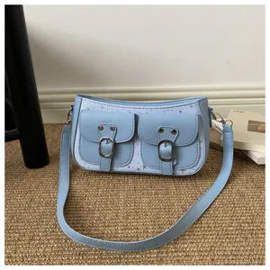 Hellblaue Achseltasche mit zwei vorderen Schnallentaschen und niedlichem Sternen-Druckstoff.