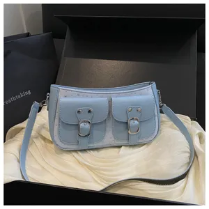 Hellblaue Schultertasche Detailansicht mit doppelten Vordertaschen und Metallschnallendesign.