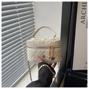 Bolso bandolera acolchado beige con cadena y elegantes dijes metálicos para mujeres.