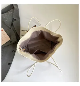 Dettagli dell'interno della borsa tote bianco crema, con grande capacità e tasche.