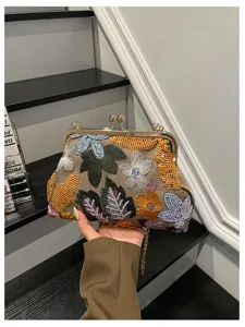 Chic borsa da sera floreale ricamata con chiusura a bacio e dettagli in paillettes.