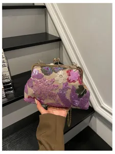 Vista dettagliata di una pochette ricamata di paillettes con chiusura e catena dorate.