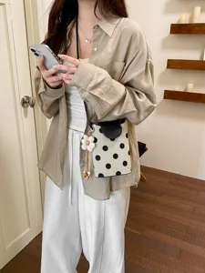 Détail de sac bandoulière à pois noir et blanc, sac à main d'été élégant pour loisirs