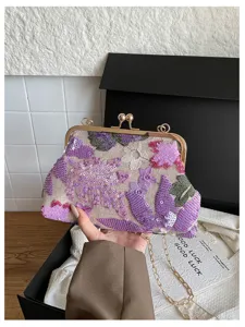 Elegante borsa da sera a pochette con ricami di paillettes e catena in metallo.