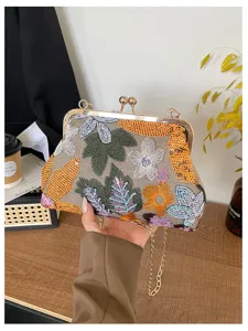 Vista dettagliata della borsa pochette vintage ricamata con paillettes floreali e telaio.