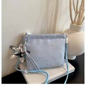 Light blue canvas crossbody bag with silver star patterns, cute star charm and shoulder strap.