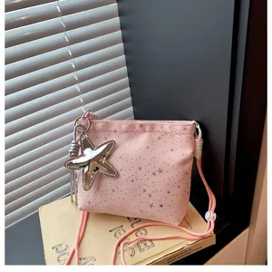 Pink crossbody bag with silver star prints and a shiny metal star charm for women.