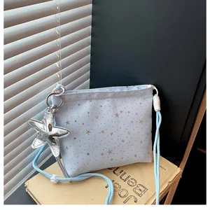 Fashionable light blue star patterned crossbody bag with cute silver starfish pendant for women.