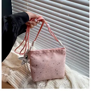 Pink crossbody bag with star print, adjustable strap and charming star pendant detail.