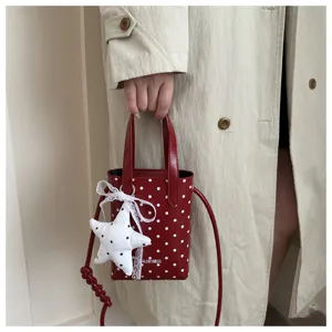 Bolso de hombro rojo con lunares para mujer con colgante de estrella y correa chic.