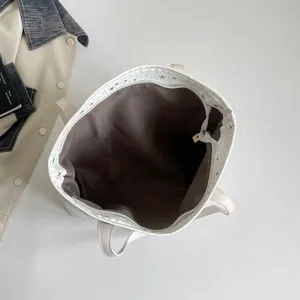 Detailansicht einer weißen Stern-Canvas-Tragetasche mit geräumigem braunem Innenraum und Henkeln.