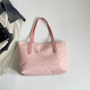 Detailaufnahme der rosa Segeltuch-Tragetasche mit silbernem Sternenmuster und rosa Griffen.