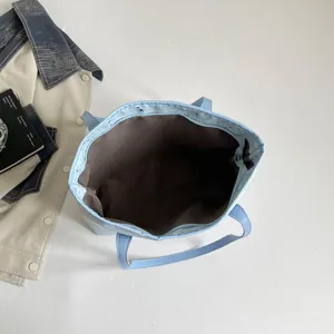 Detaillierte Draufsicht auf hellblaue Canvas-Tasche mit Sternenmuster und Innenfutter.