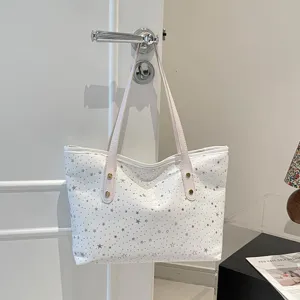 Nahaufnahme einer weißen Segeltuchtasche mit Sternen-Print, lässige Umhängetasche für den Alltag.