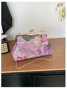 Primo piano della borsa da sera con paillettes ricamate e chiusura metallica a scatto dorata.