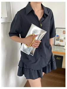 Zilveren metallic enveloppe clutch tas met gouden C-ring handvat, stijlvolle avondtas.