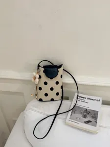 Sac bandoulière en toile à pois avec rabat en cuir noir et pendentif fleur mignon.