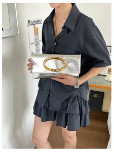 Metalzilveren envelop clutch tas met opvallende gouden C-gesp minimalistische modehandtas.