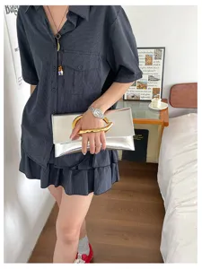 Minimalistische zilveren envelop clutch tas met gouden C-handvat voor damesmode.