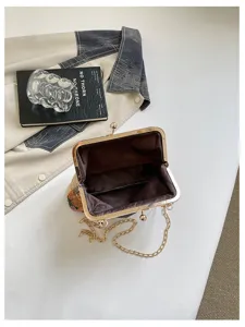Vista dettagliata di una borsa da sera alla moda ricamata con fiori e tracolla a catena.