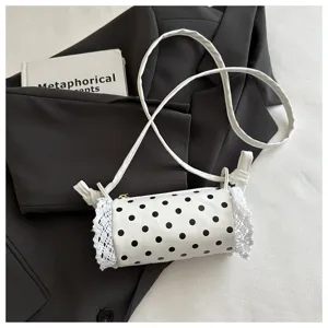 Borsa a tracolla cilindrica a pois bianchi nel dettaglio, con grazioso bordo in pizzo.