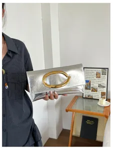 Minimalistische zilveren metallische enveloppedames tas met opvallende gouden C-metaalgesp.