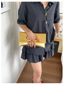 Stijlvolle metallische envelop clutch tas voor dames met opvallende C-vormige handgreep.