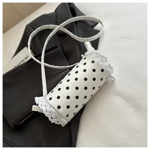 Borsa a secchiello a pois bianchi con delicato bordo in pizzo, dettaglio tracolla elegante.