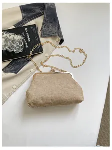 Dettaglio di una pochette vintage con chiusura a scatto, elegante borsa in tessuto.