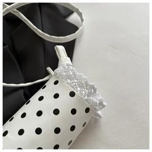 Borsa a secchiello a pois per bambini vista dettaglio con bordo in pizzo bianco e nero.
