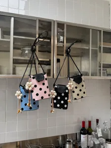 Vue détaillée de petits sacs à bandoulière à pois suspendus au mur de la cuisine.