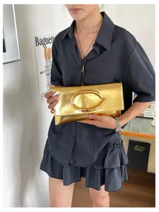 Metallic gouden enveloppe clutch tas met opvallende C-gesp sluiting voor stijlvolle damestypering.