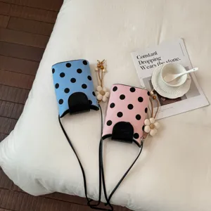 Sac à bandoulière chic à pois avec pendentif floral, idéal pour les vacances d'été.