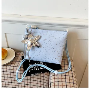 Light blue crossbody bag detail showing silver star pattern and large star pendant accessory.