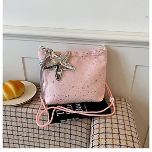 Pink shoulder bag with silver star pendant, detailed view of the star pattern and strap.