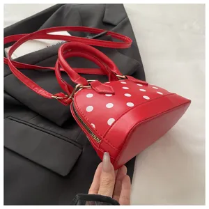 Red polka dot shell handbag with top handle and crossbody strap, stylish casual daily bag.