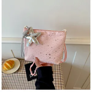 Pink bucket shoulder bag with silver star prints and star charm for stylish daily wear.