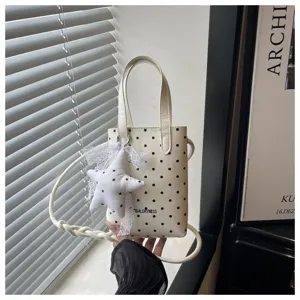 Elegante bolso de mano blanco con lunares y colgante de estrella, bandolera versátil y chic.