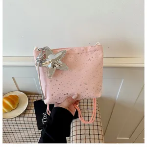 Pink drawstring crossbody bag with silver star prints and metal star charm for women daily use.