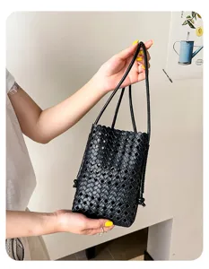 Vue détaillée du sac téléphone seau en cuir tressé noir, texture souple, style décontracté.
